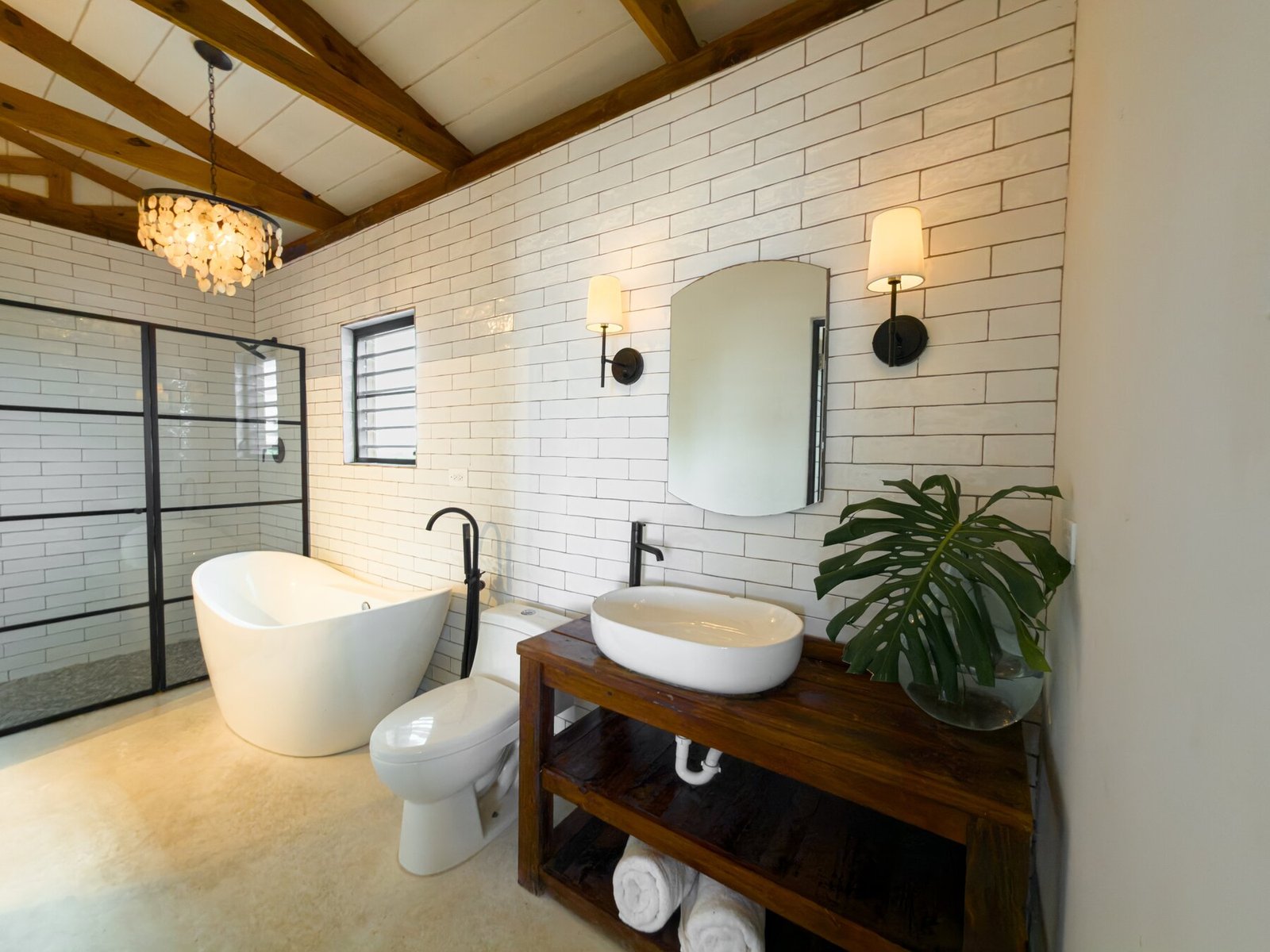 Bathroom with walk-in shower, freestanding tub, and shell chandelier