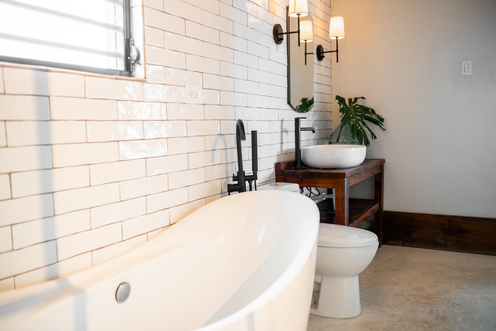 Penthouse bathroom tub, toilet, and wood vanity with vessel sink