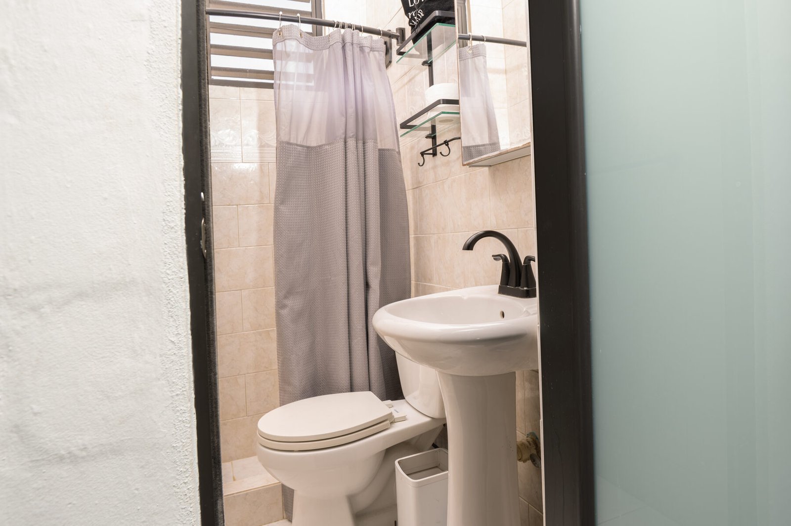 Bathroom with pedestal sink and shower