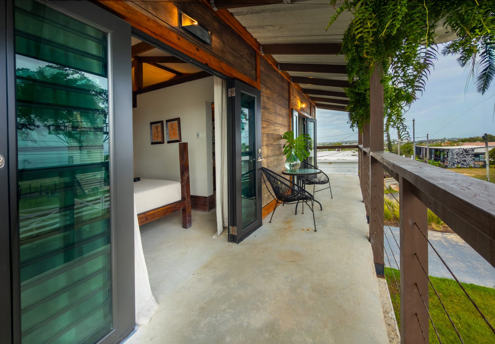 Penthouse balcony with bedroom visible and view toward town