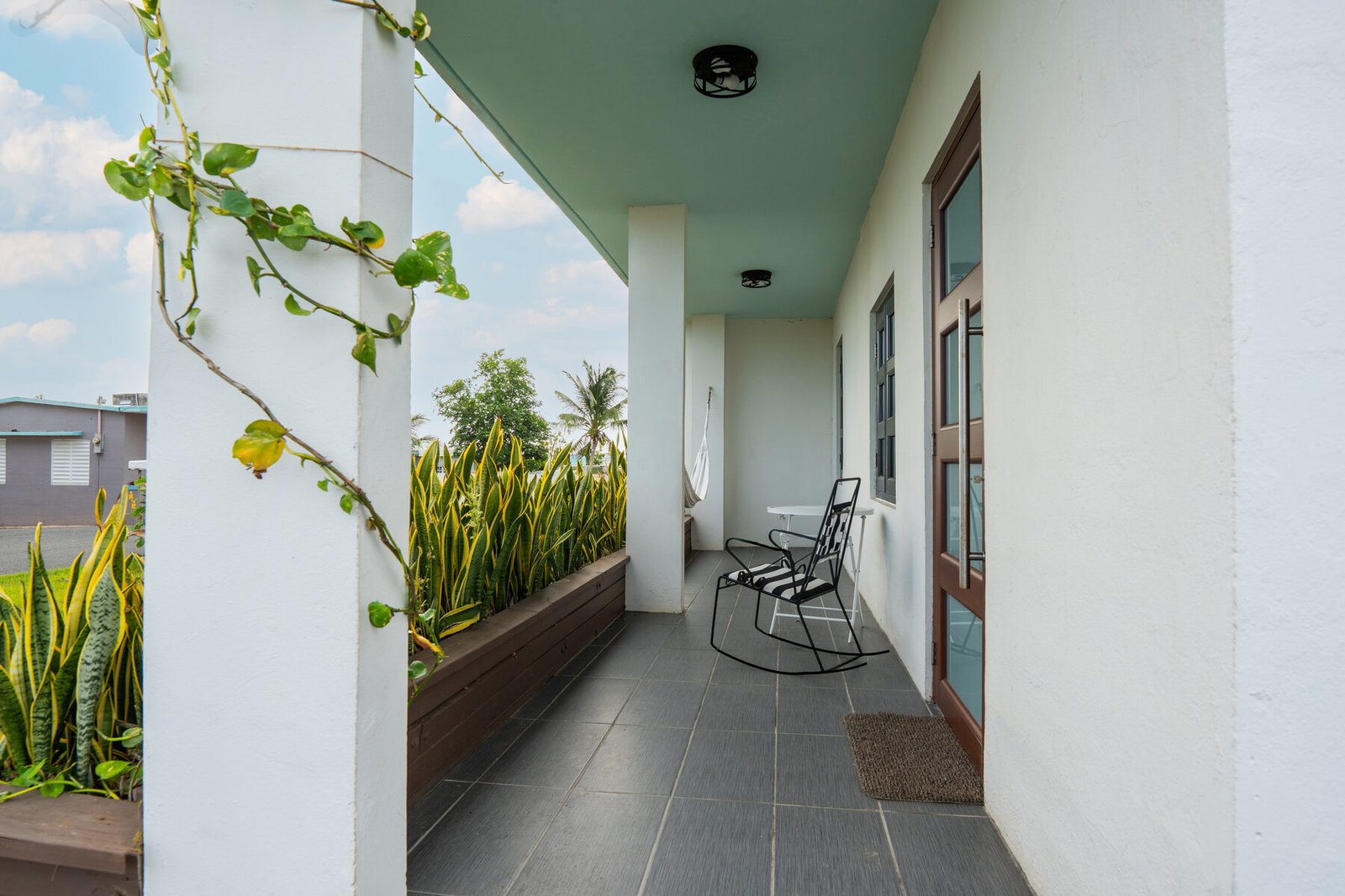 Casita Blanca + Penthouse angled front view with hammock and rocking chair
