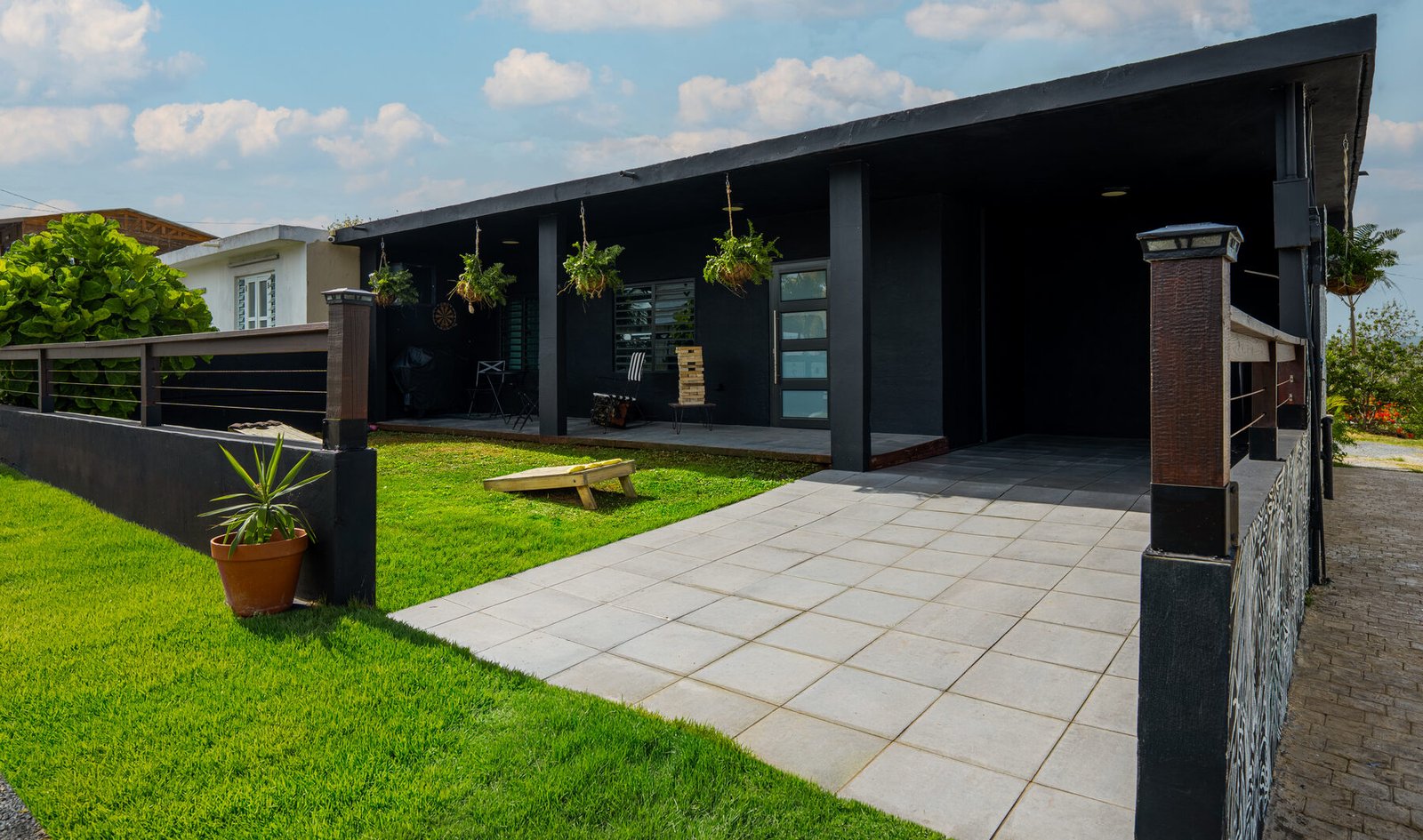 Casita Negra exterior porch with hanging plants and yard games