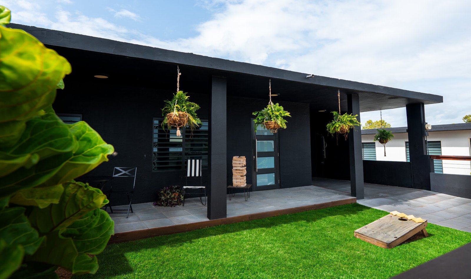 Casita Negra black exterior with covered porch and hanging plants