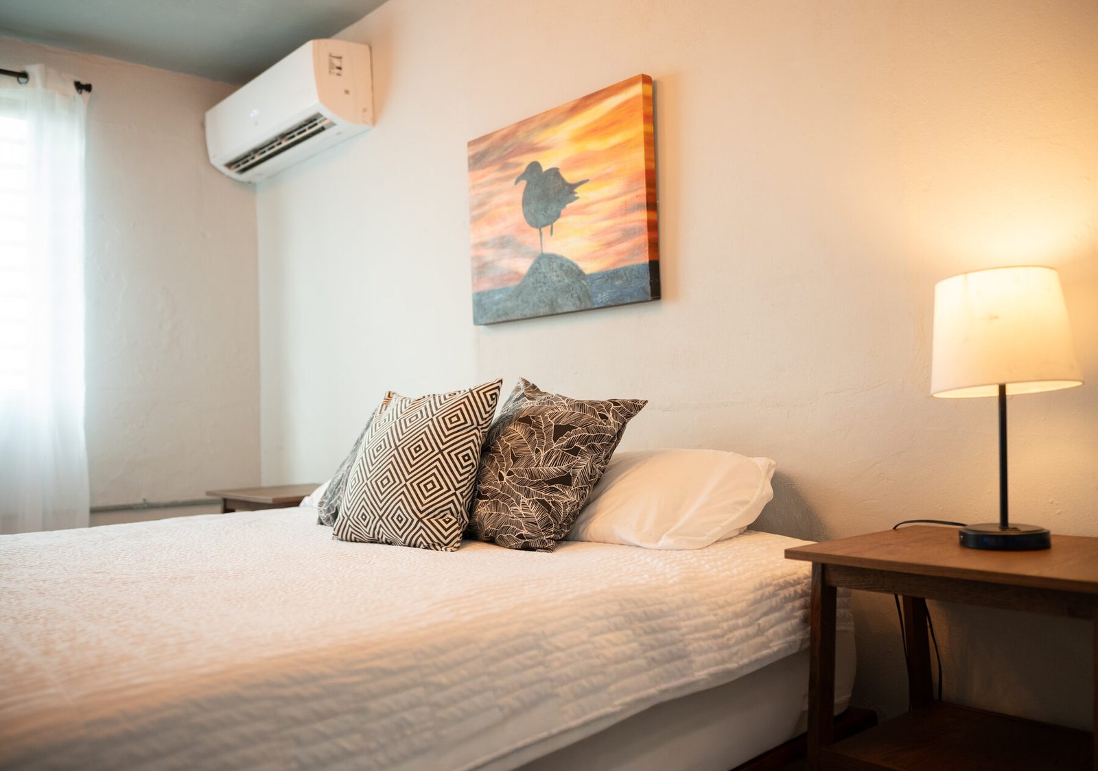 Bed with wall-mounted A/C and side table