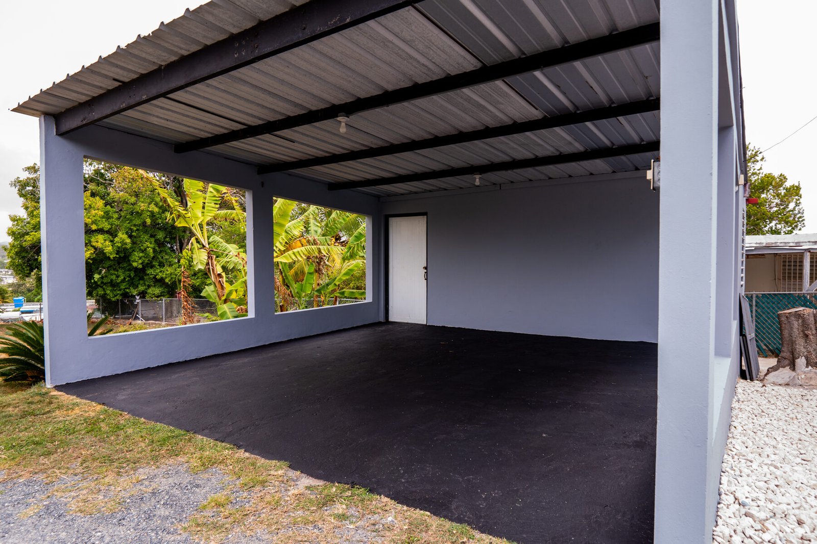 Covered marquesina with banana trees visible